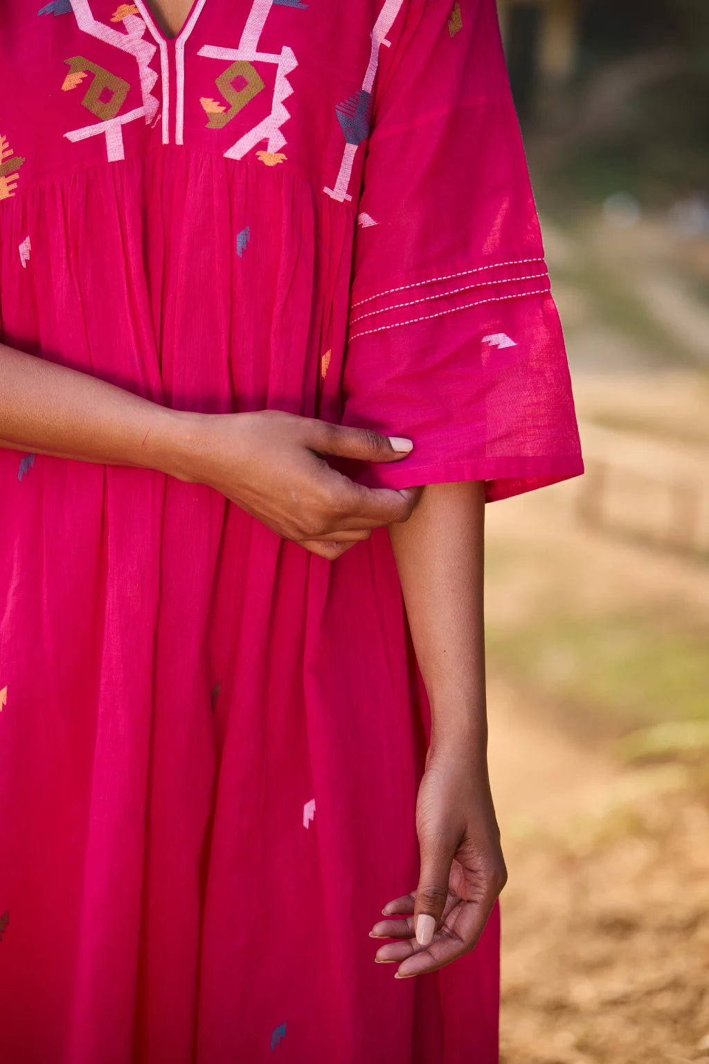 Sarron Raktima Dress, pink cotton Jamdani dress with a large geometric yoke motif and Kantha-worked sleeves.