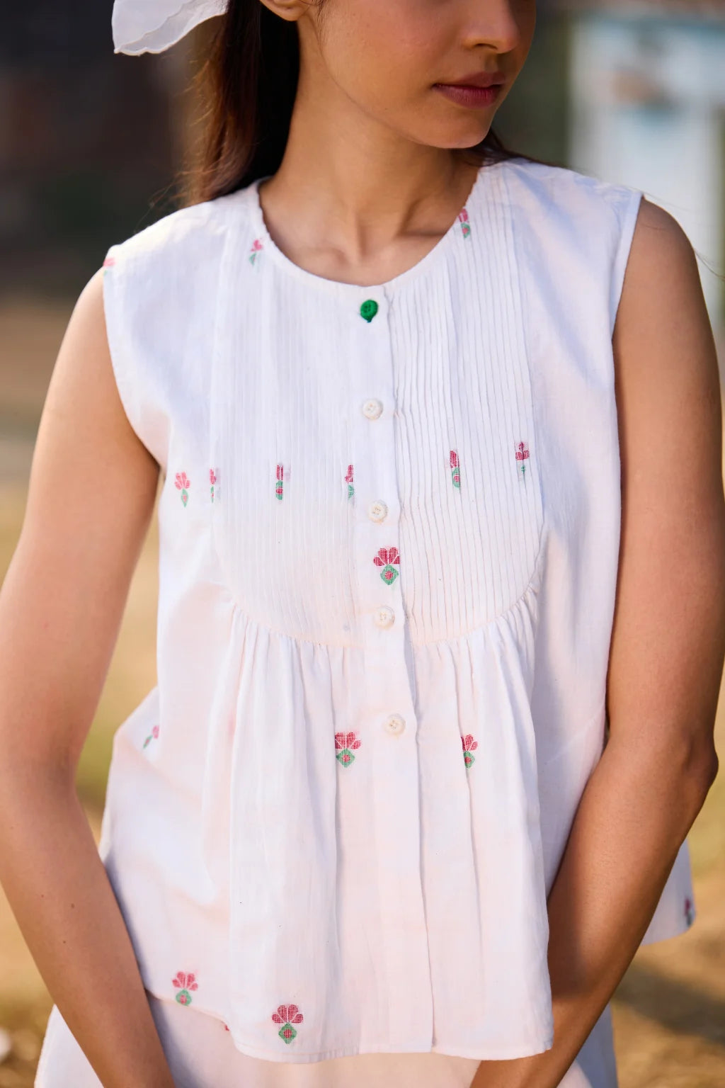 Sarron Shiuli Top, sleeveless white cotton Jamdani top with handwoven floral motifs and front pintucks.