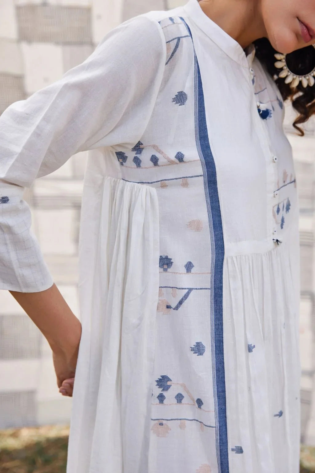Sarron Yashvi Dress, white cotton Jamdani dress with handwoven blue motifs and a mandarin collar.