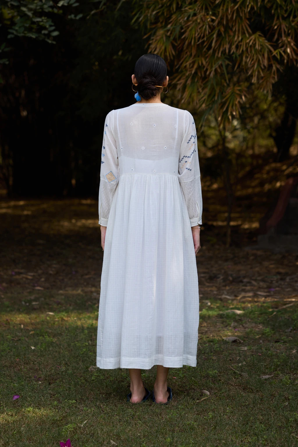 Sarron Ananta Dress, white cotton maxi patchwork Jamdani dress with asymmetric blue and gold motifs and a geometric skirt.