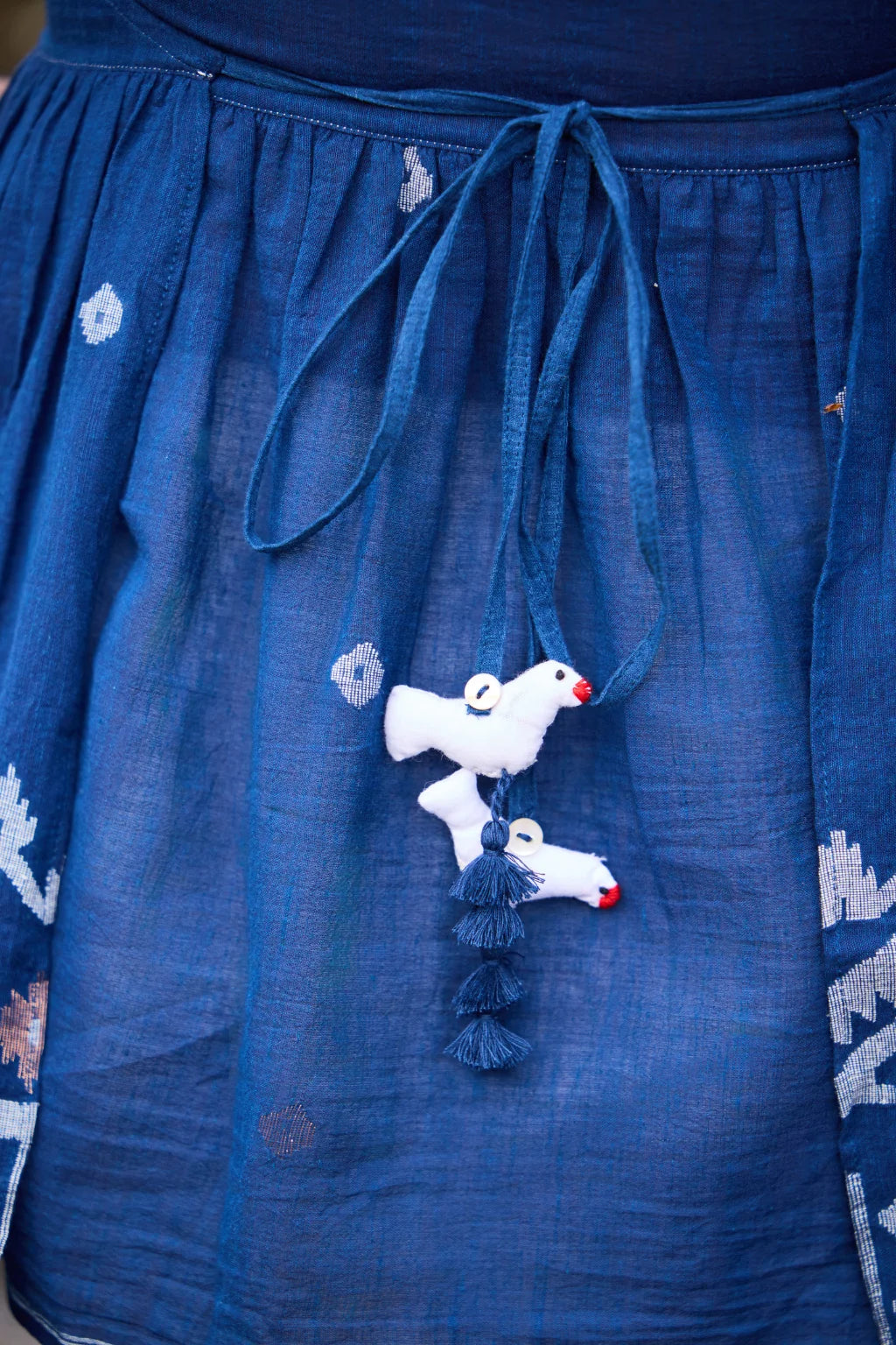 Sarron Aparajita Top, sleeveless blue cotton Jamdani top with tie-ups and a handcrafted bird tassel.