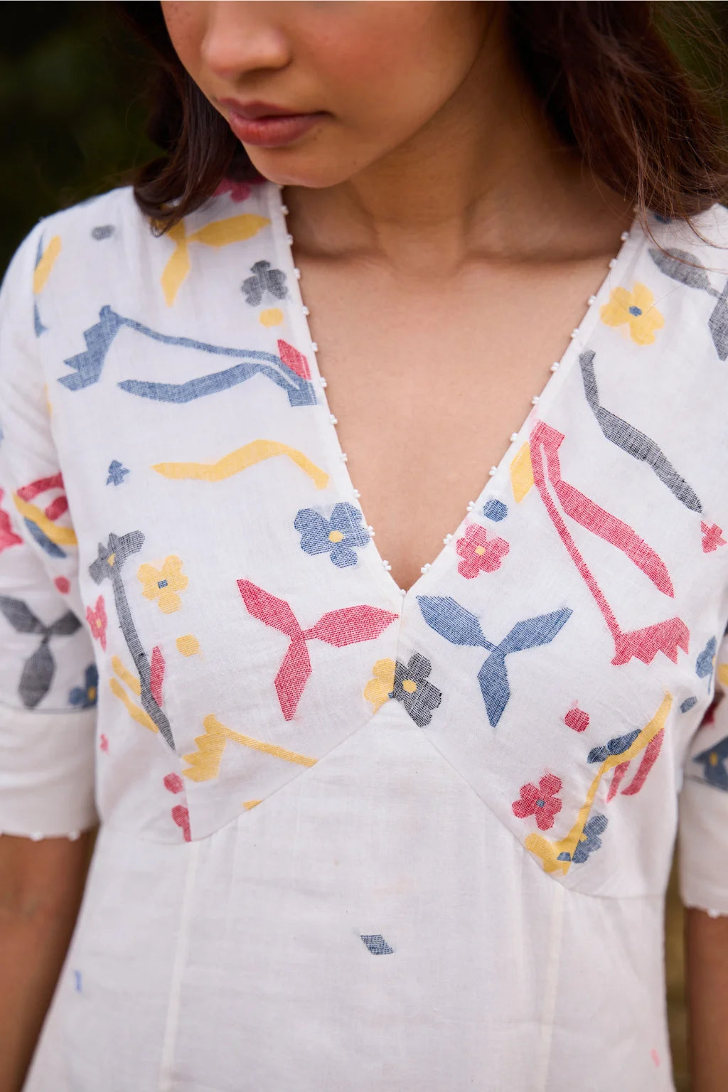 Sarron Giribala Dress, white cotton Jamdani A-line dress with handwoven floral motifs and beaded neckline.