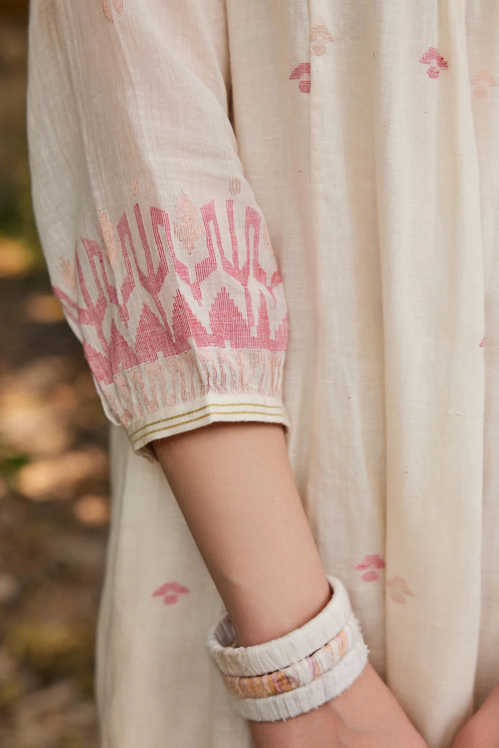Sarron Khanak Dress, off-white cotton Jamdani dress with red and copper zari motifs and floral hand embroidery.