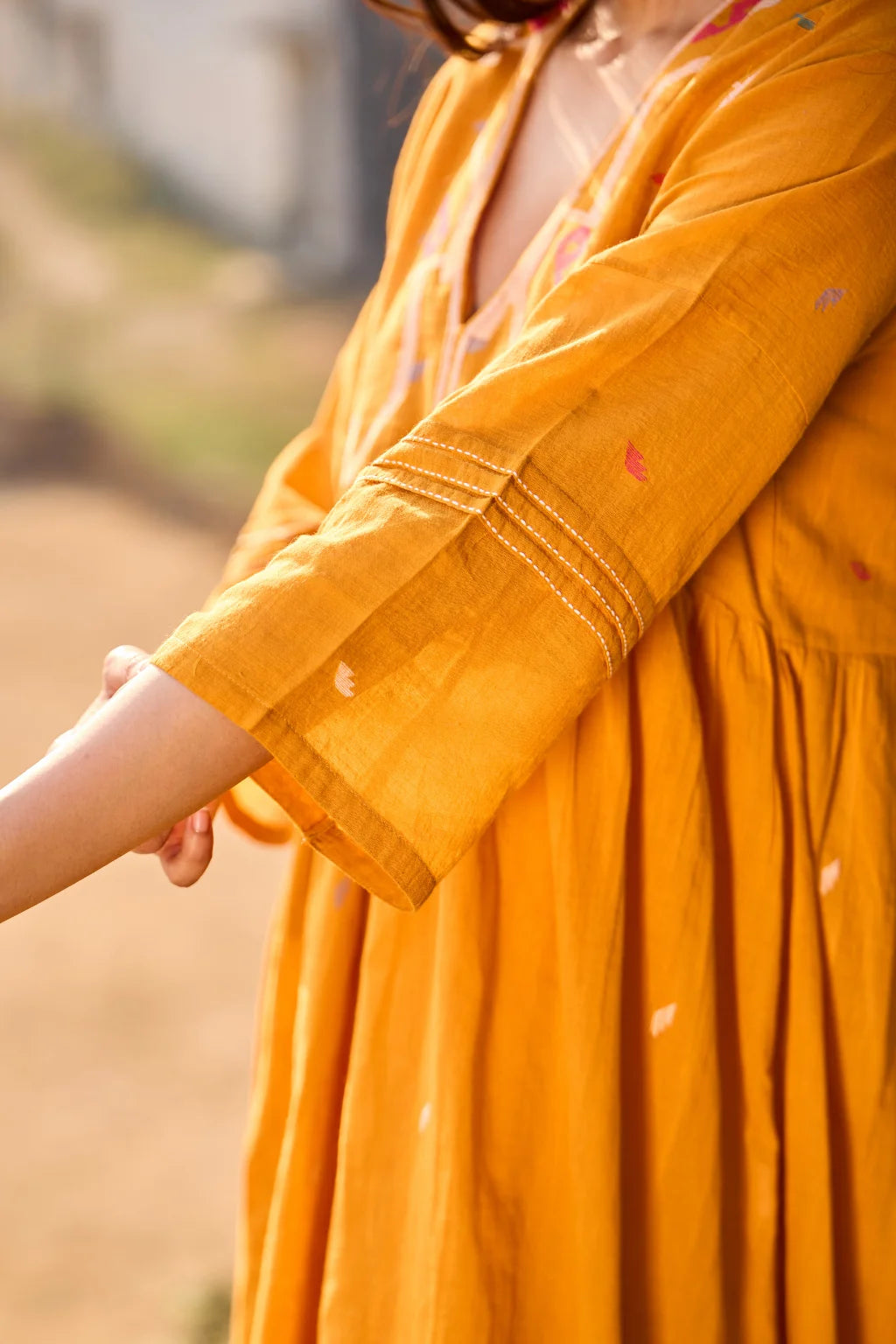 Sarron Ushnota Dress, mustard yellow cotton Jamdani V-neck dress with a geometric yoke motif and Kantha-worked sleeves.