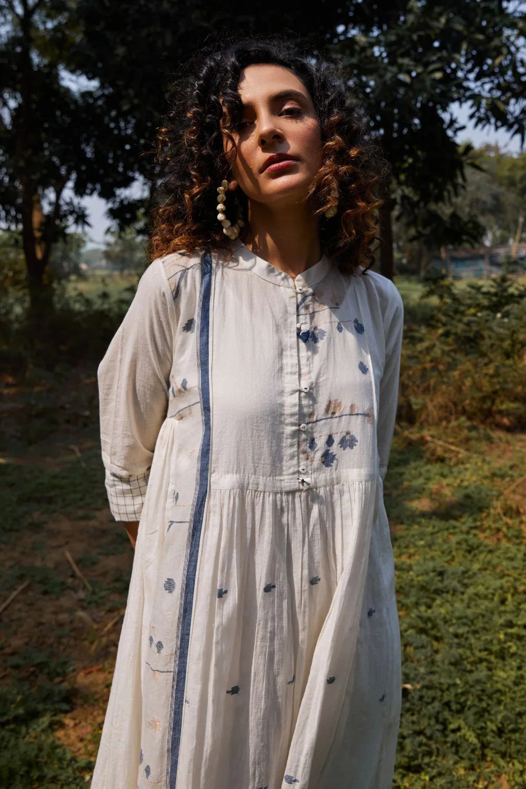 Sarron Yashvi Dress, white cotton Jamdani dress with handwoven blue motifs and a mandarin collar.