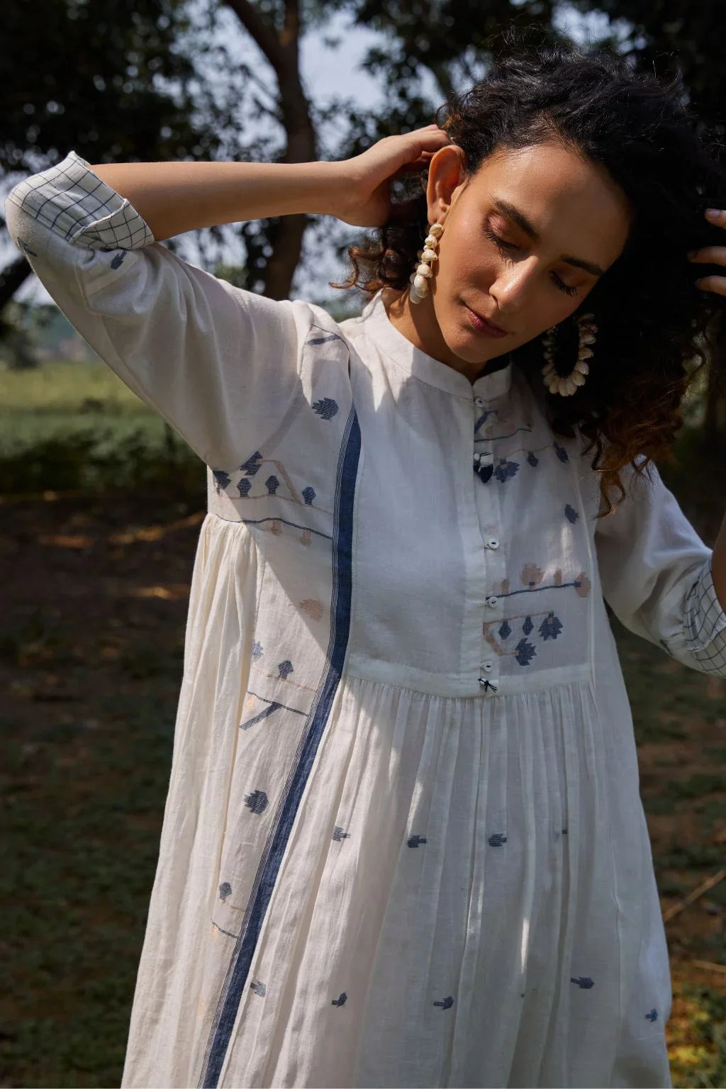 Sarron Yashvi Dress, white cotton Jamdani dress with handwoven blue motifs and a mandarin collar.